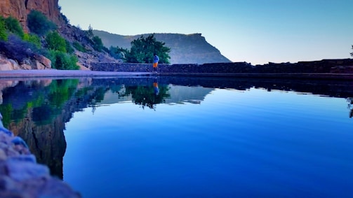 A serene landscape with a person reflecting on their journey.