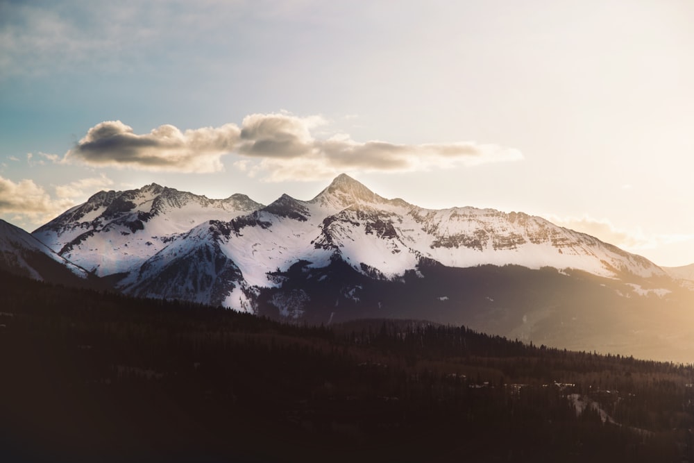 Tagsüber schneebedeckter Berg unter weißen Wolken