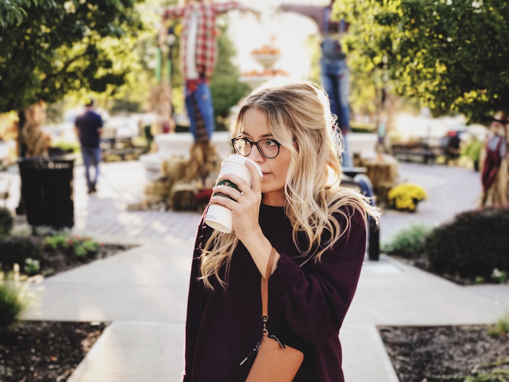 femme buvant sur une tasse blanche