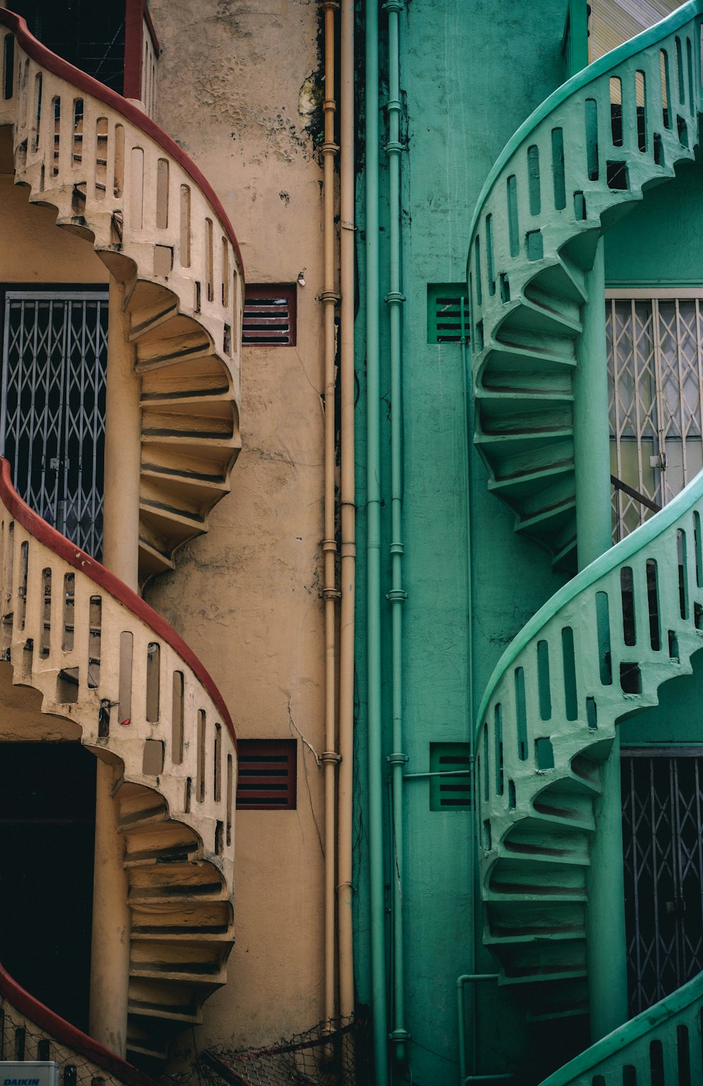 建物横のベージュと緑のコンクリートの螺旋階段
