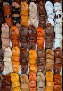 Soft brown leather sandals displayed on natural wooden surface