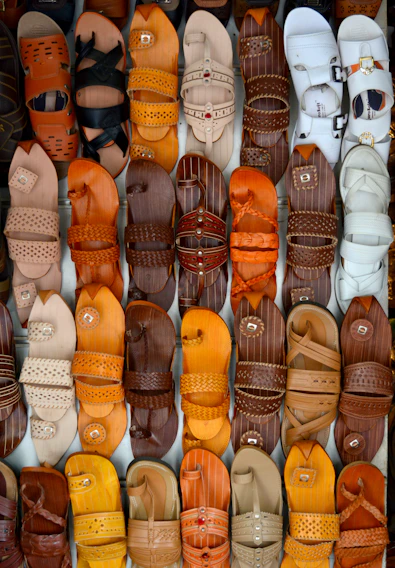 A close-up of stylish Moroccan men's sandals on a rustic wooden surface.