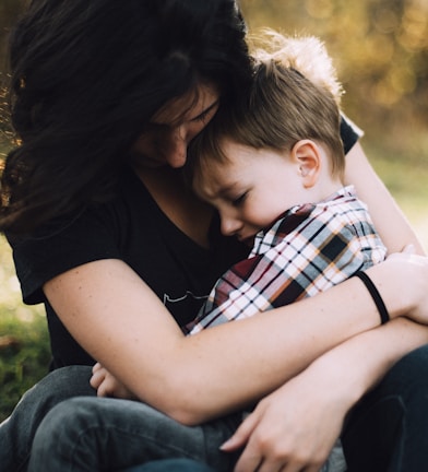 woman hugging boy on her lap