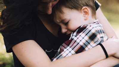 woman hugging boy on her lap