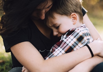 woman hugging boy on her lap