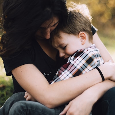 woman hugging boy on her lap