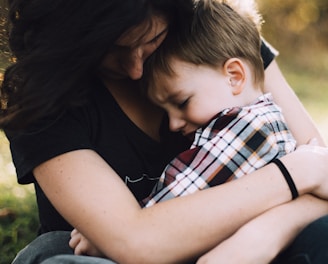 woman hugging boy on her lap