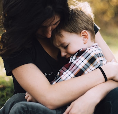 woman hugging boy on her lap