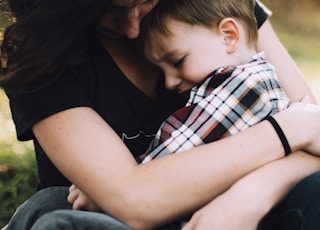 woman hugging boy on her lap