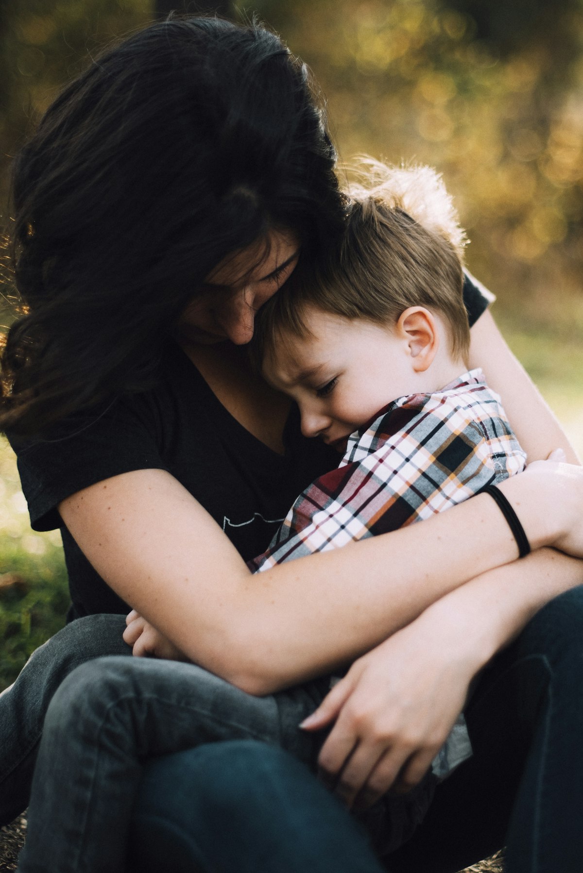 A woman tenderly holding a boy on her lap, parent-child attentive moment