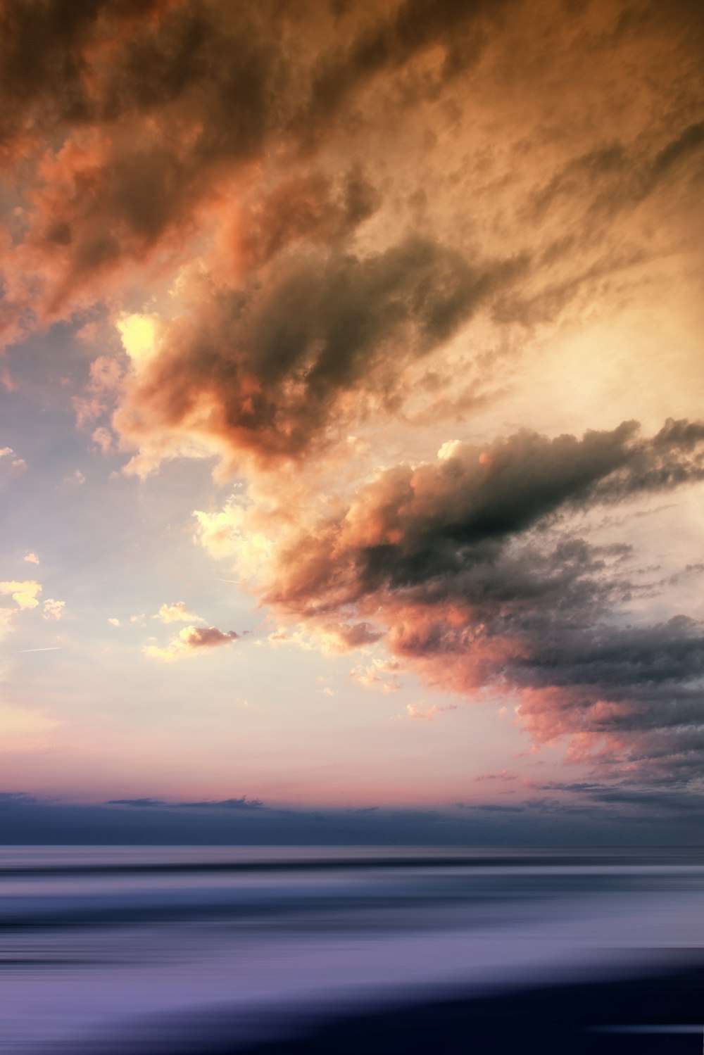 calm sea under cloudy sky at daytime