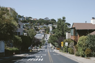 A calm suburban street where students practice driving under the watchful eye of their instructor.