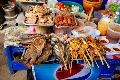 Colorful assortment of street food dishes displayed on a vibrant outdoor stall.