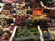 A colorful assortment of seasonal vegetables arranged neatly in wooden crates at a farmer’s market.