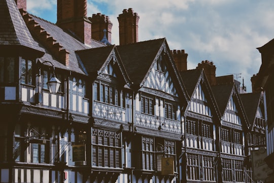 white and brown concrete building under white clouds in Chester United Kingdom