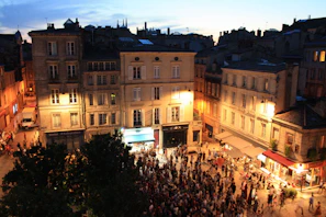 A historic city square alive with evening lights and gentle crowds