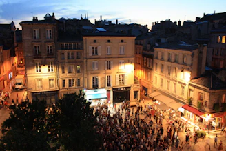 A historic city square alive with evening lights and gentle crowds