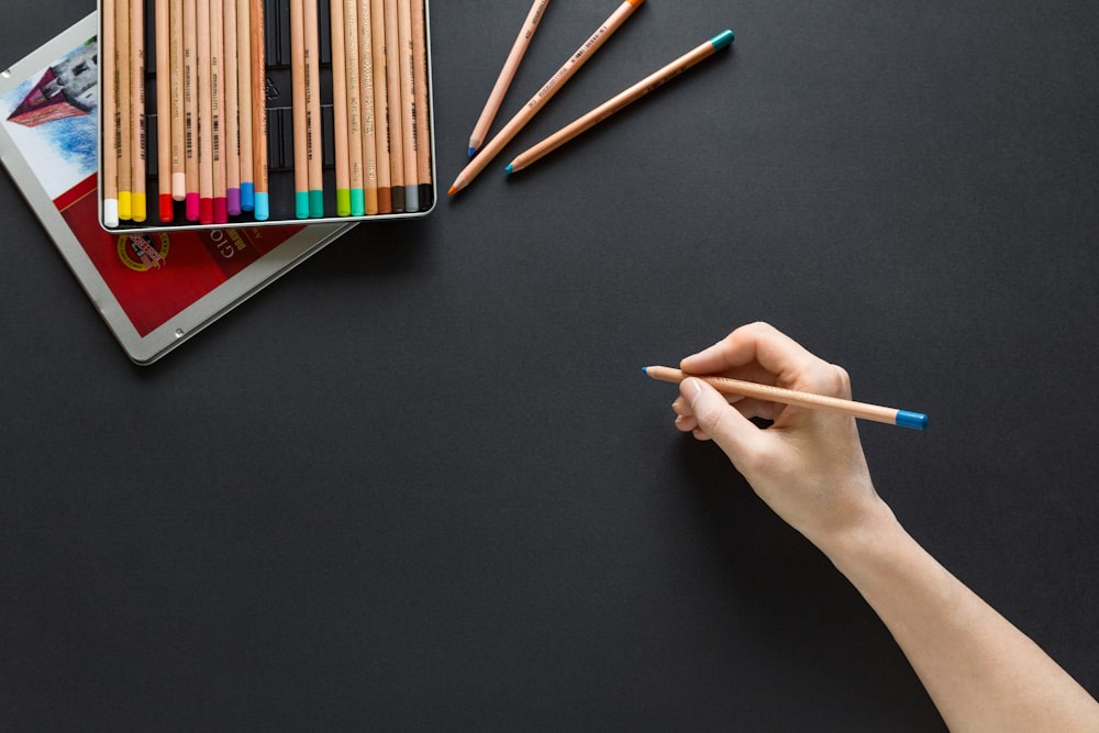 person holding brown pencil