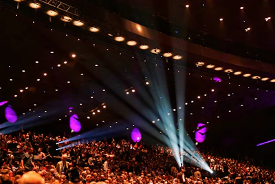 A vibrant crowd gathered at a summit, engaged and inspired under warm lighting.