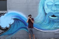 A photographer framing a shot of a colorful mural.
