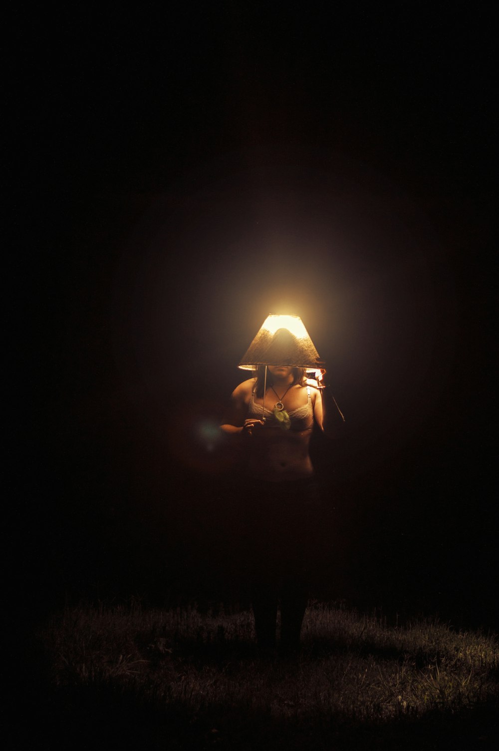 man in black jacket sitting on brown grass field during night time