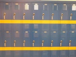 A row of custom steel lockers with a smooth powder-coated surface in a gym setting.