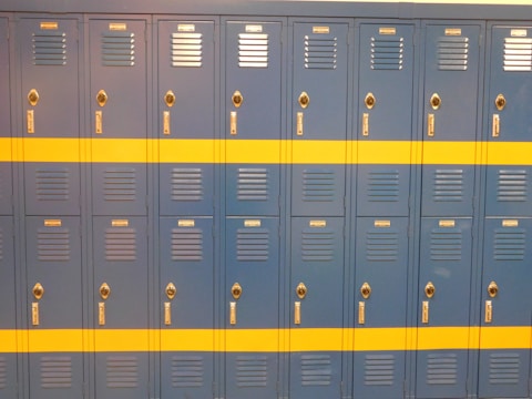 A row of custom steel lockers with a smooth powder-coated surface in a gym setting.