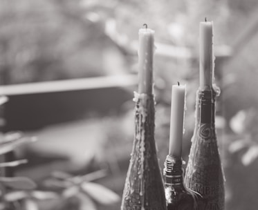 Close-up of a delicate blessed oil bottle surrounded by soft candlelight