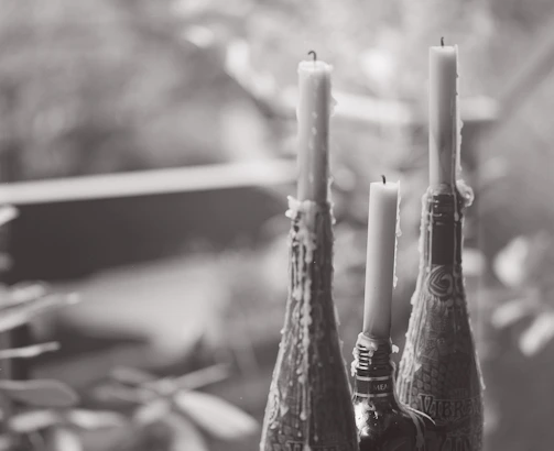 A close-up of amber-colored ritual oil bottles glowing softly in candlelight.