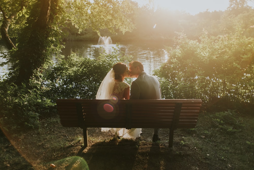 newlywed sitting on bench white kissing