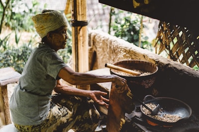 Traditional Korean monk carefully roasting bamboo salt over an open flame in a rustic setting.