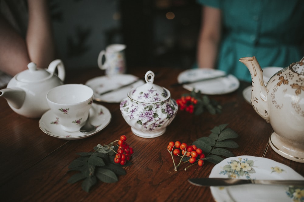 photo of white floral tea set on brown wooden table