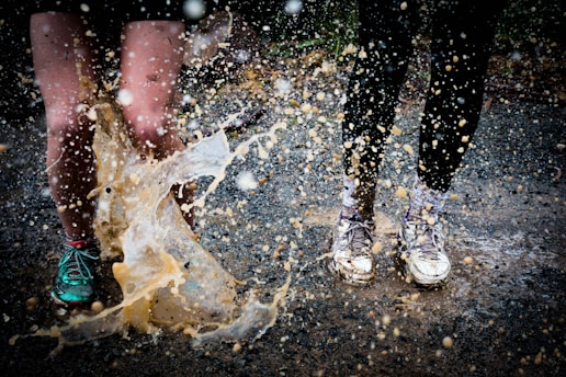 water splashing on two running people