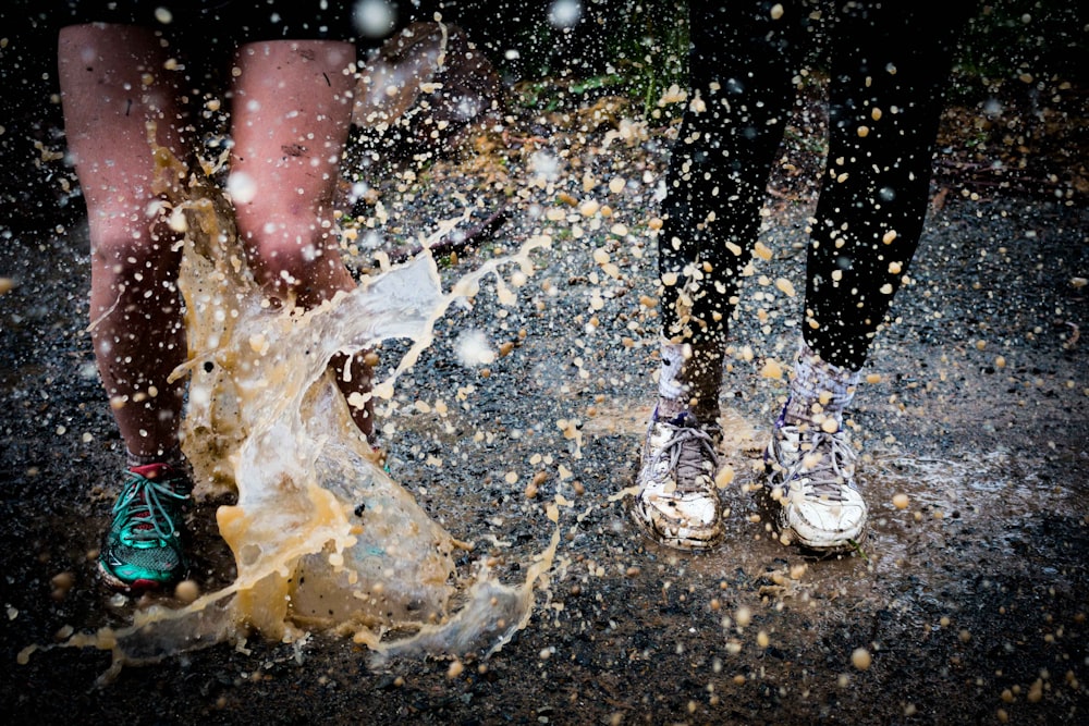 water splashing on two running people