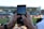Close-up of a smartphone displaying live sports scores with a blurred stadium background.