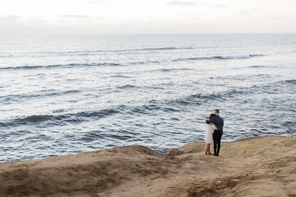 man and woman facing body of water