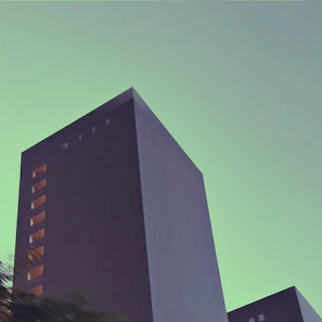 A minimalist charcoal-toned skyscraper silhouette against a soft off-white sky.