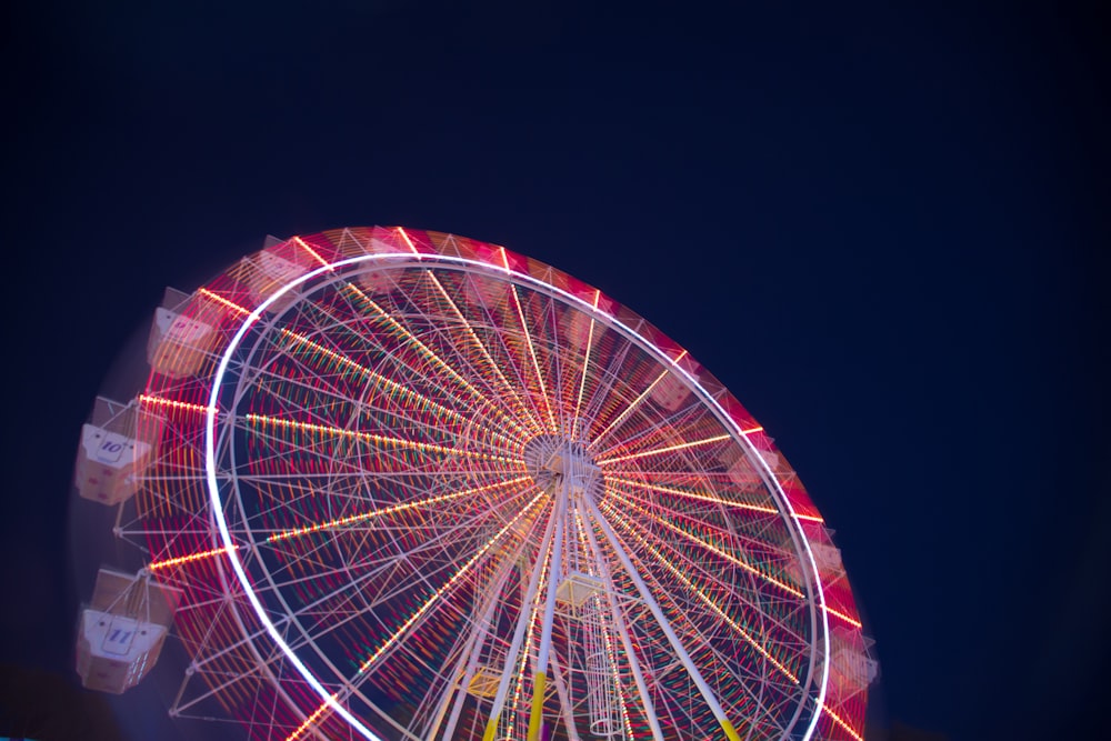 timelapse low angle of white and red ferris wheel