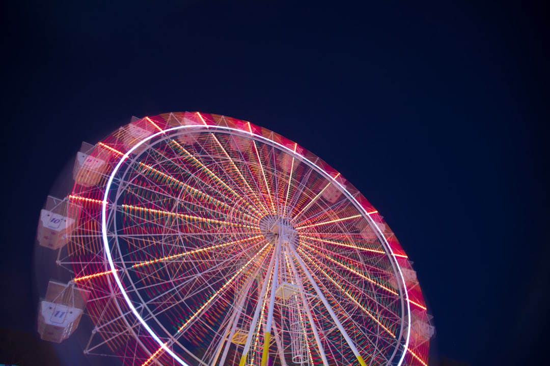 timelapse low angle of white and red ferris wheel