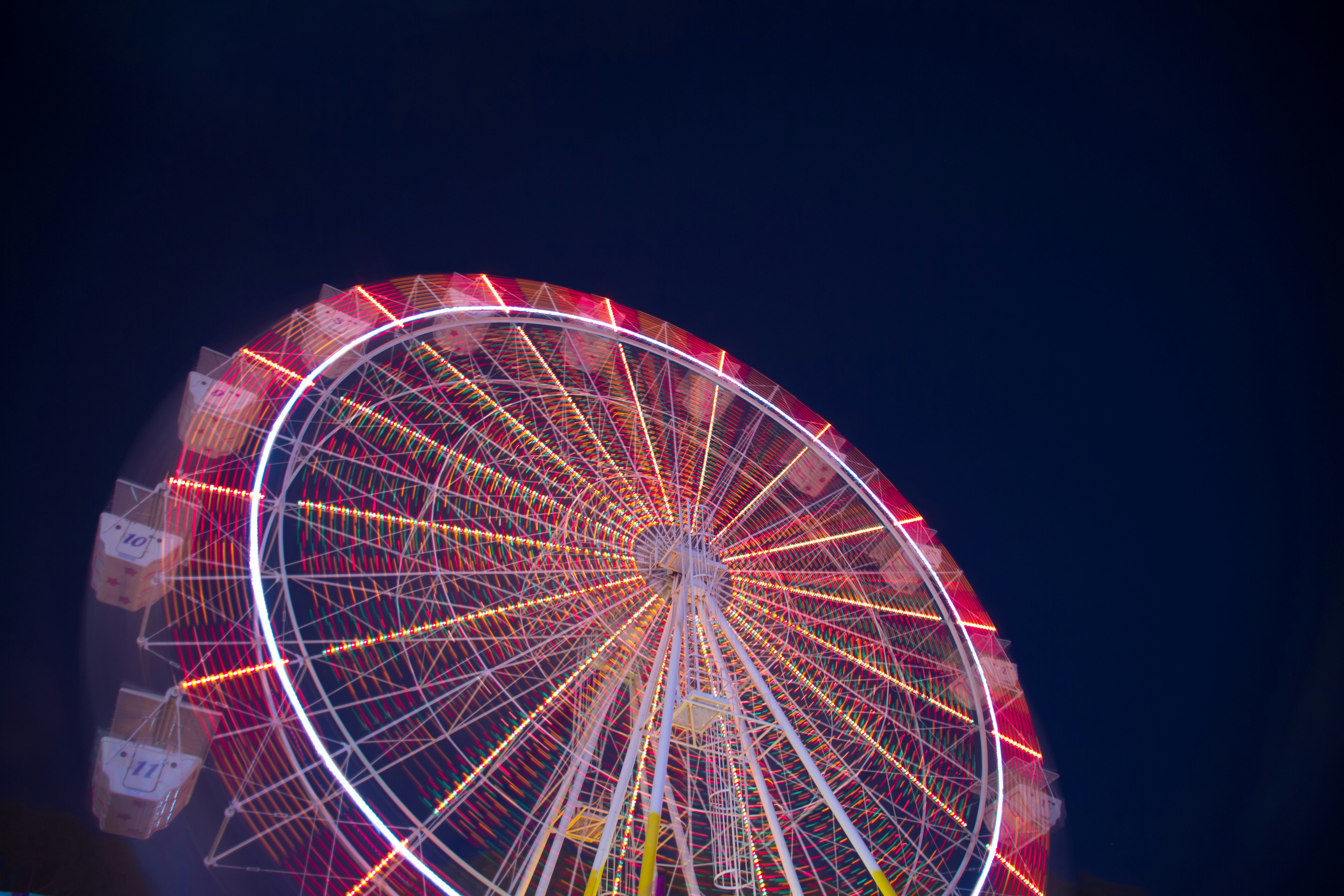 timelapse low angle of white and red ferris wheel