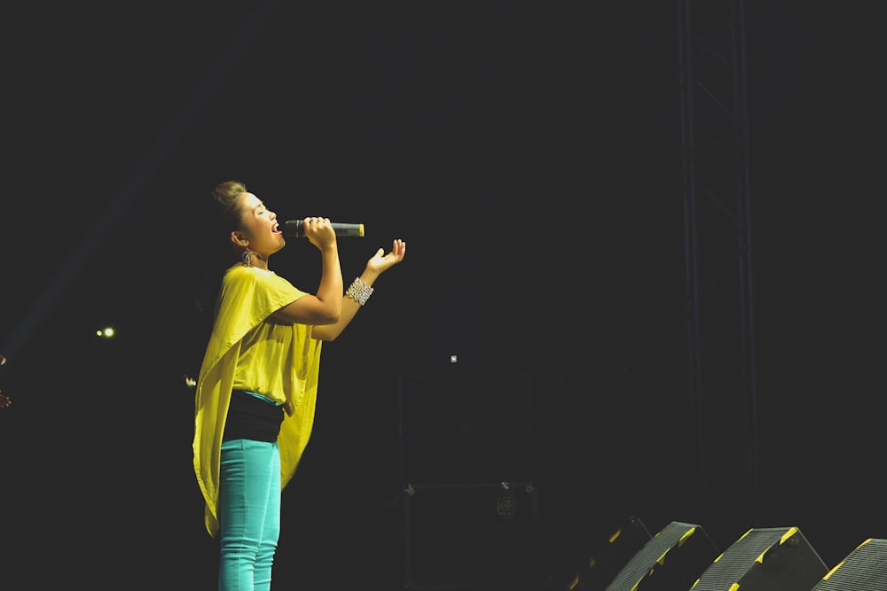 woman holding a microphone performing on stage