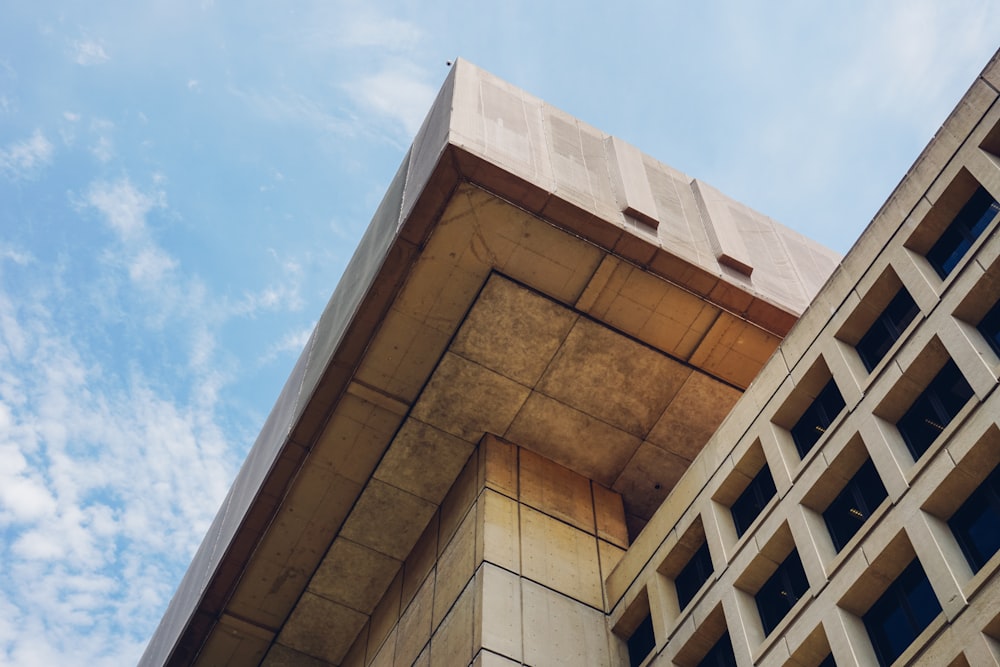 Edifício de concreto marrom sob o céu azul durante o dia