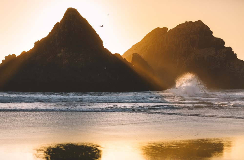 silhouette of mountain near body of water during daytime