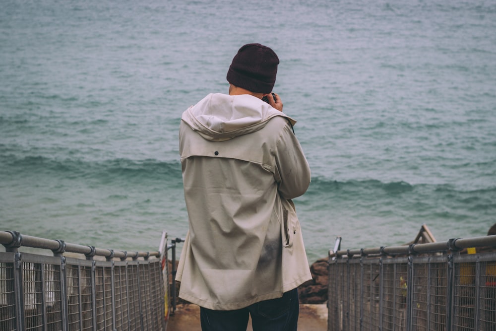 person standing on pathway near sea