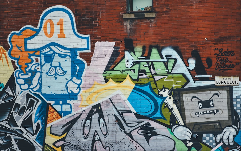 Une peinture graffiti d’un personnage en forme de téléviseur.