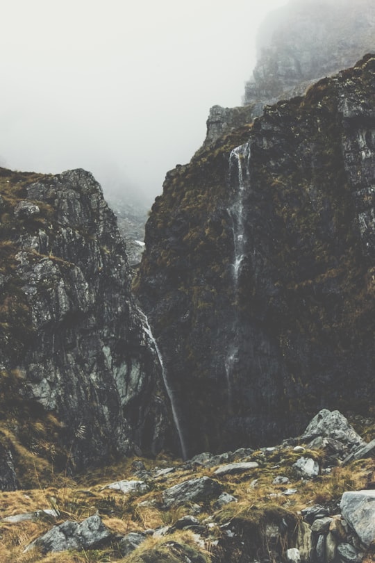 photography of foggy waterfalls in Mount Aspiring National Park New Zealand