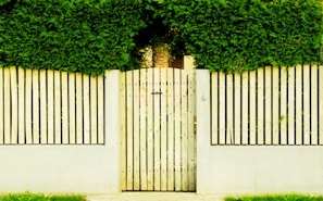 Before and after shots of a wooden gate motorization project in a residential garden.