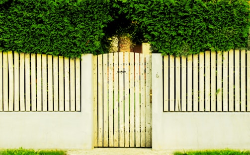 A beautifully crafted wooden fence with natural stain blending into a lush backyard garden.