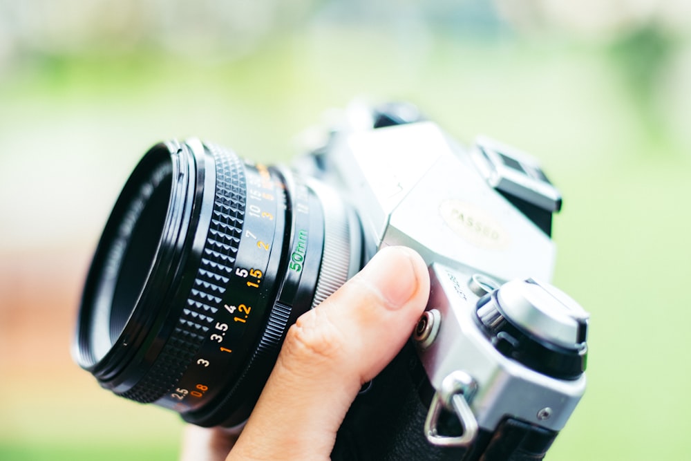 person holding black DSLR camera