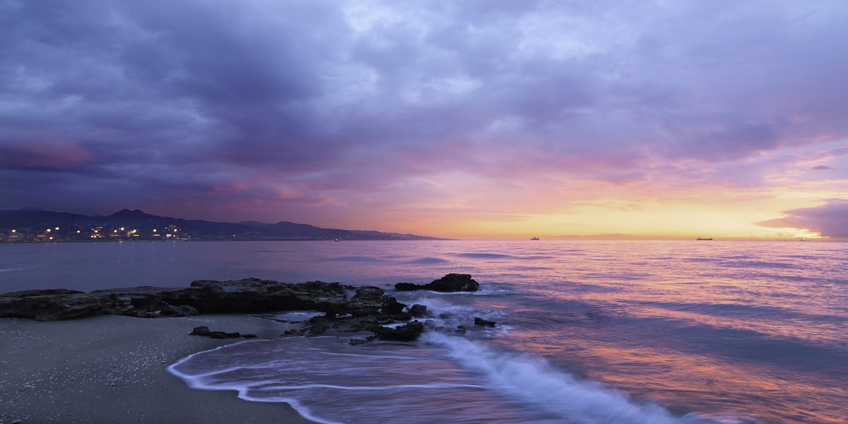 waves of body of water splashing on sand